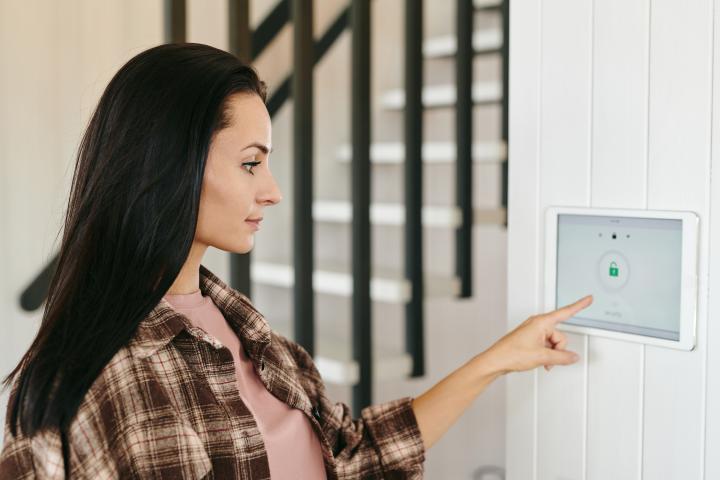 alarm system young housewife pointing at tablet with security