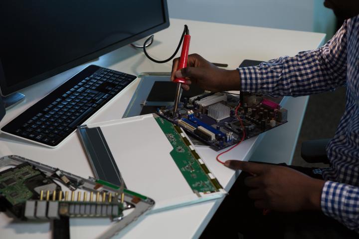 computer repair computer engineer repairing motherboard at desk